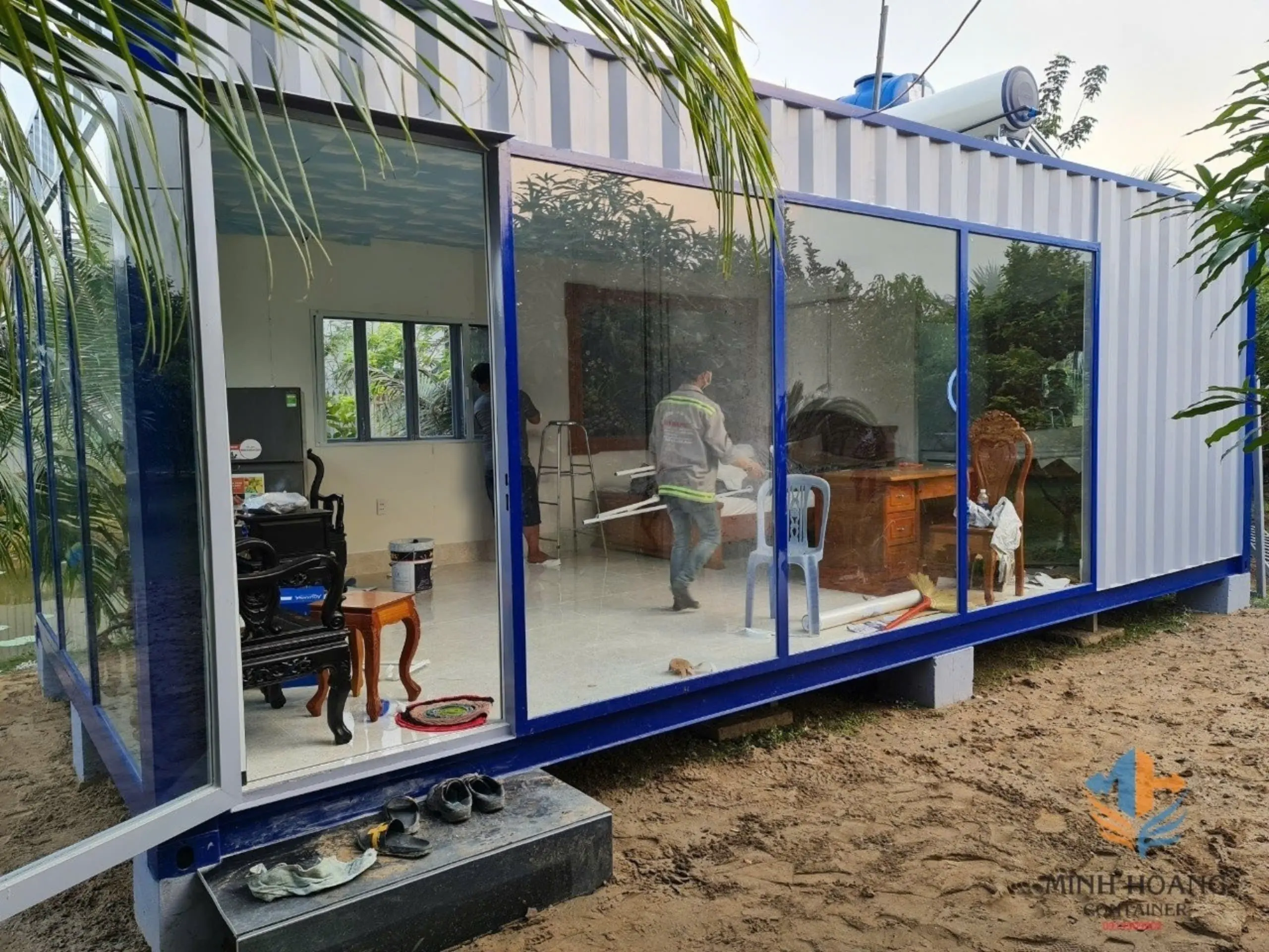 Container nhà ở ghép xám viền xanh dương khung cửa kính có toilet